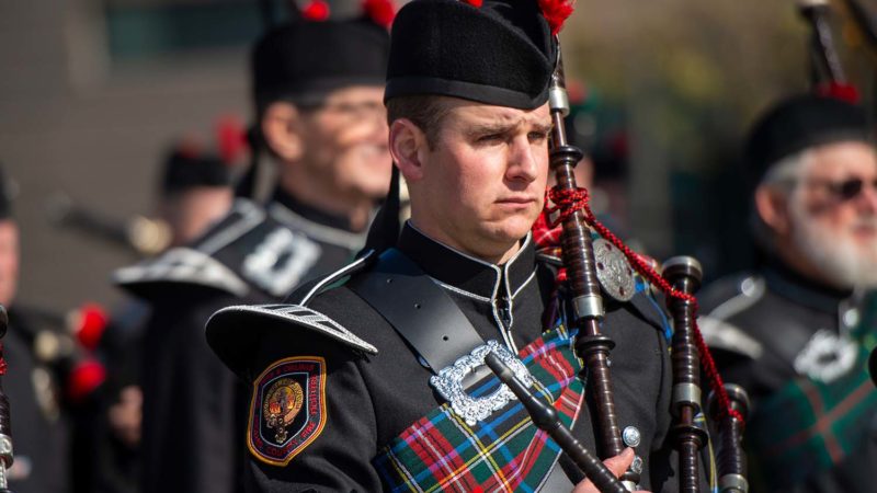Man in black uniform holding bagpipes
